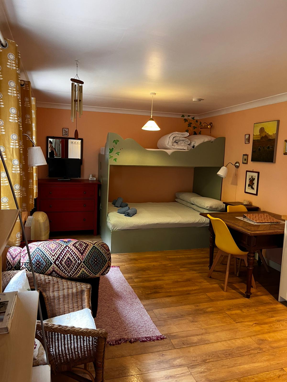 The cottage's open-plan room with seating, table, kitchen and beds