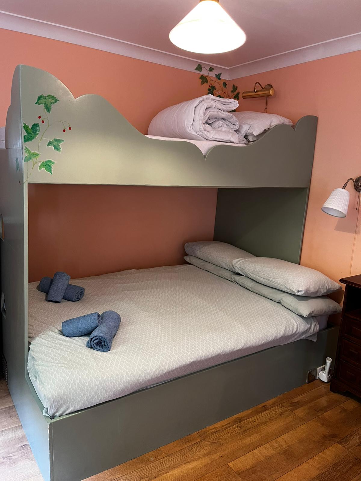 Double bed with a single bunk bed above it