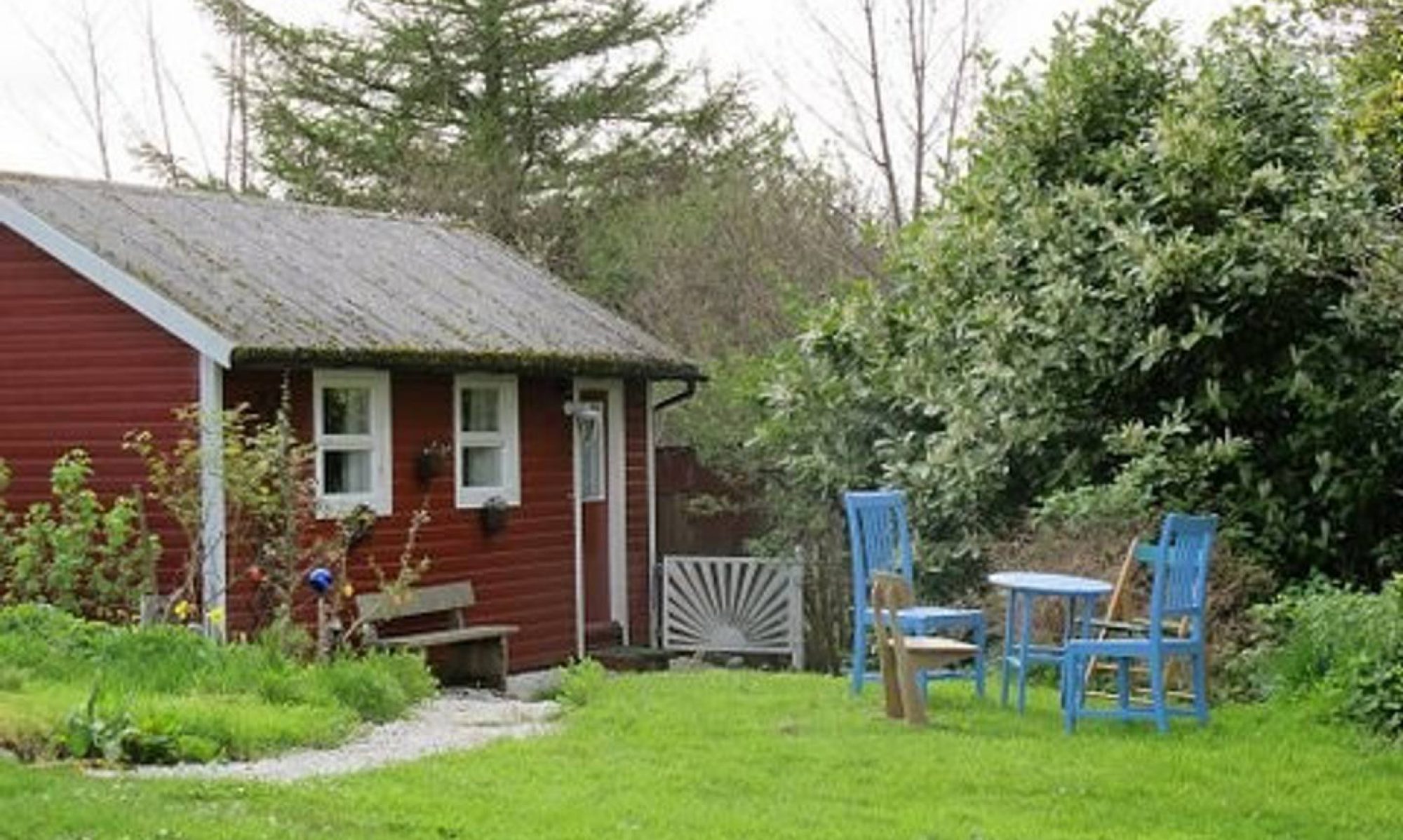 The red wooden cottage at Struanlea, surrounded by garden greenery